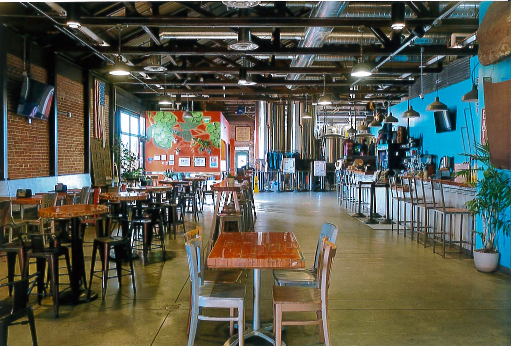 Interior view facing south showing restored flooring, exposed ceiling trusses and new brewery equipment